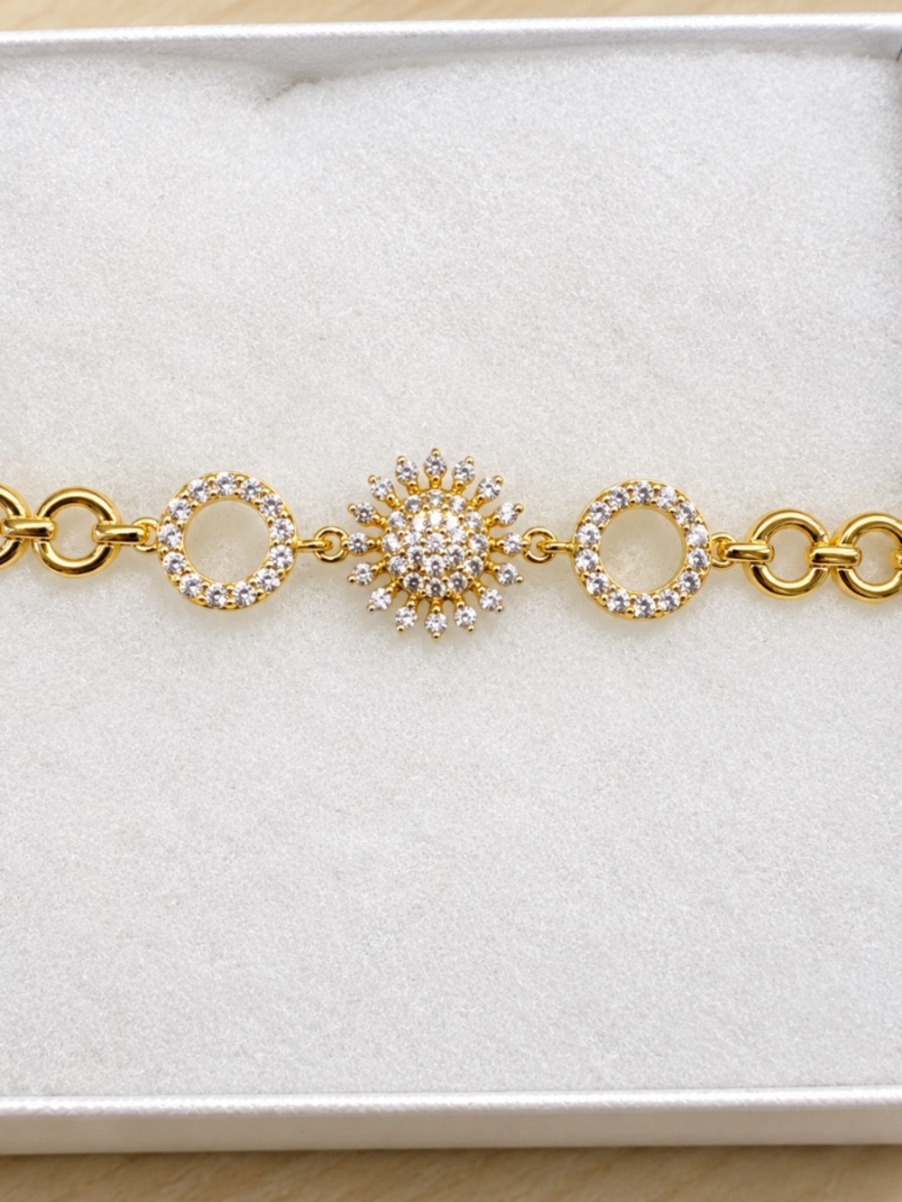 Gold open circle bracelet with CZ flower and circle pave accents